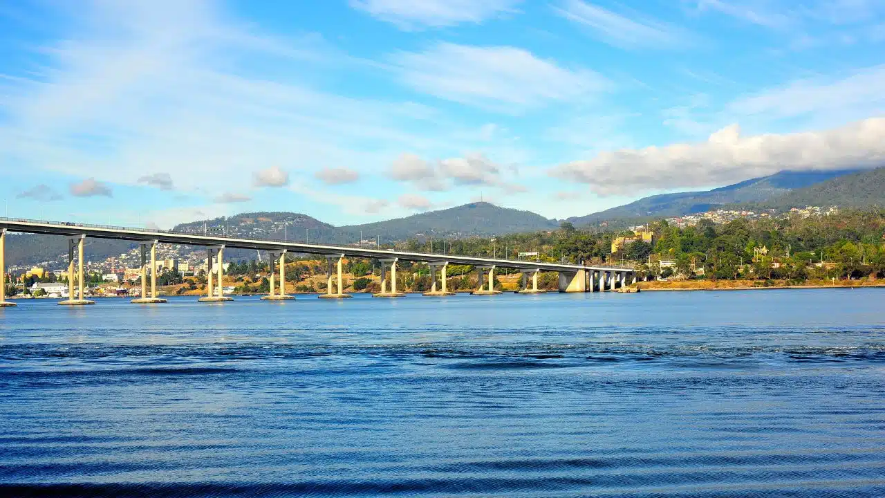 Tasman Bridge spanning the River Derwent in Hobart, Tasmania, Australia, with calm blue waters, forested hills, and clear skies showcasing one of Tasmania's most iconic waterfront landmarks